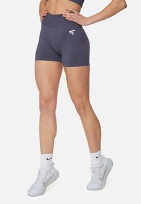 Vysoké tmavošedé športové šortky vyrobené z elastického materiálu, s plochým pásom a malým bielym logom na boku.