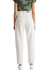 Pantalones de mezclilla blancos de tiro alto con un corte relajado, que cuentan con pierna recta, dos bolsillos traseros y un parche de cuero marrón en la cintura.