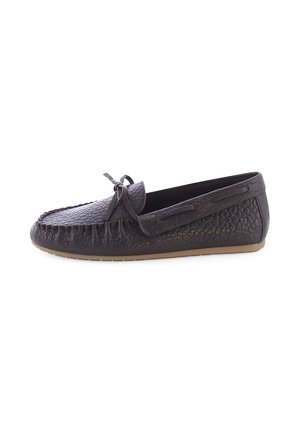 Donkerbruine leren mocassin met structuur, met een strik bovenop en een platte beige zool, zijaanzicht op een witte achtergrond.