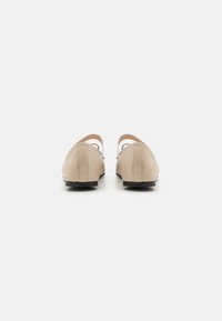 Beige ballet kingad sileda nahkviimistluse, avatud seljaosa ja madala musta kontsaga. Omavad peenelt õmmeldud detaile õmbluste ümber.