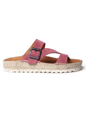Pink suede slide sandal with crisscross straps, black buckle accent, jute-wrapped sole, and a textured footbed for comfort.