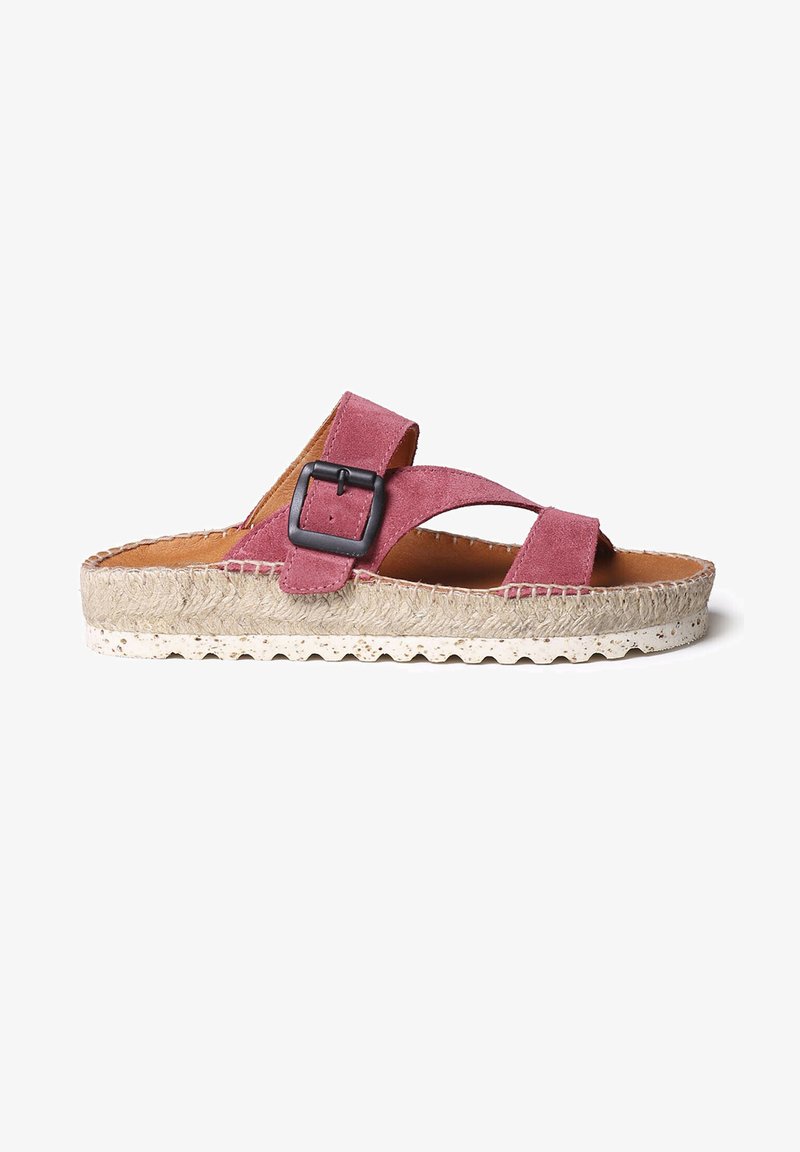 Sandale à semelle en suède rose avec des brides entrecroisées, une boucle noire comme accent, une semelle en jute et un coussin de pied texturé pour le confort.