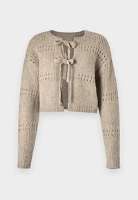 Svetle béžový zkrácený kardigan vyrobený z žebrovaného pleteného materiálu. Má kulatý výstřih, dlouhé rukávy a dvě přední tkaničky. Otevřený design s malými výřezy.