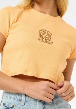 T-shirt court à manches courtes en tissu côtelé orange clair avec un imprimé graphique marron indiquant "San Carlos". Encolure carrée et coupe ajustée.