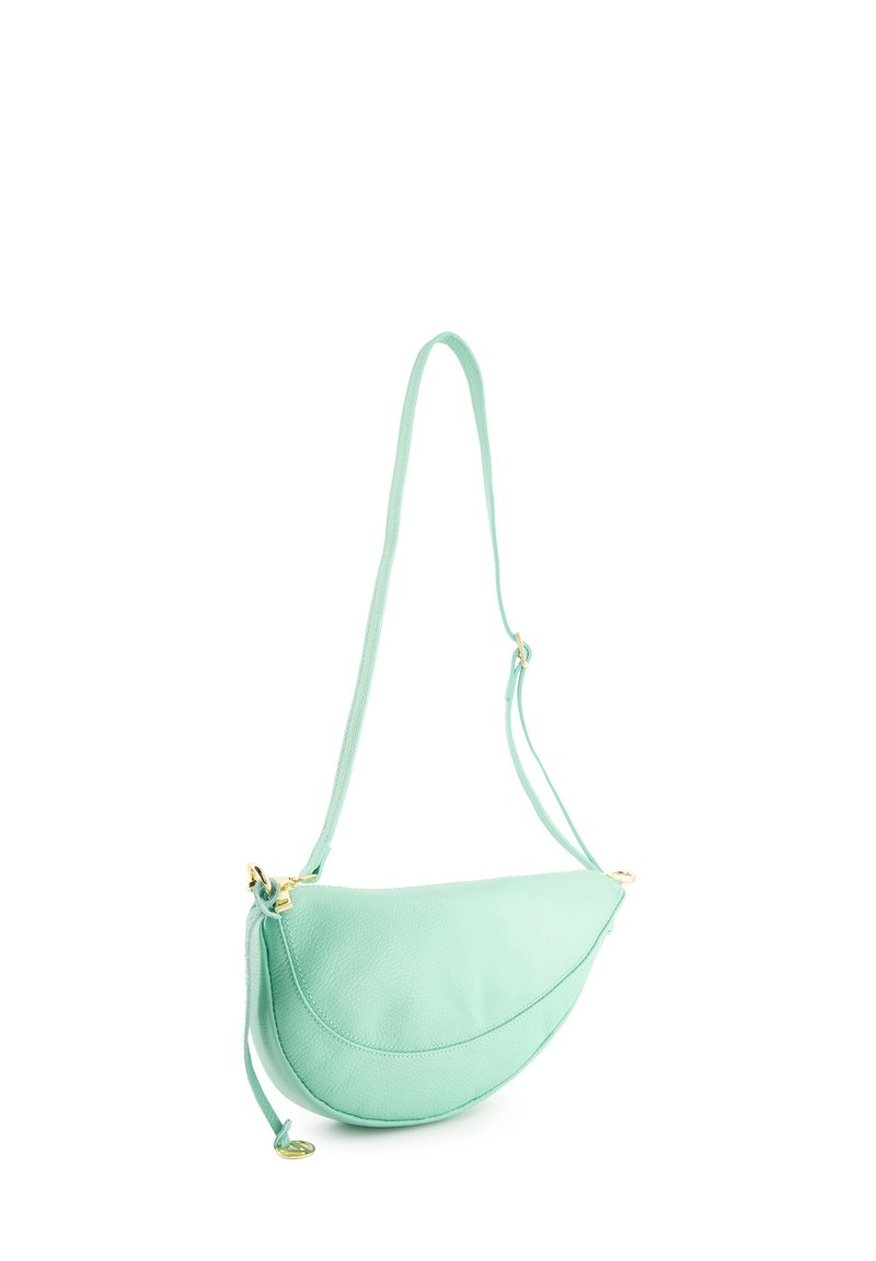 Mintgrøn læder crossbody taske med en buet form, der har gyldent hardware, en lang strop og en glat, struktureret overflade.
