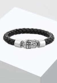 Bracciale in pelle nera intrecciata con chiusura in tonalità argento con incisione. La chiusura dispone di un meccanismo di chiusura sicuro e una superficie liscia.