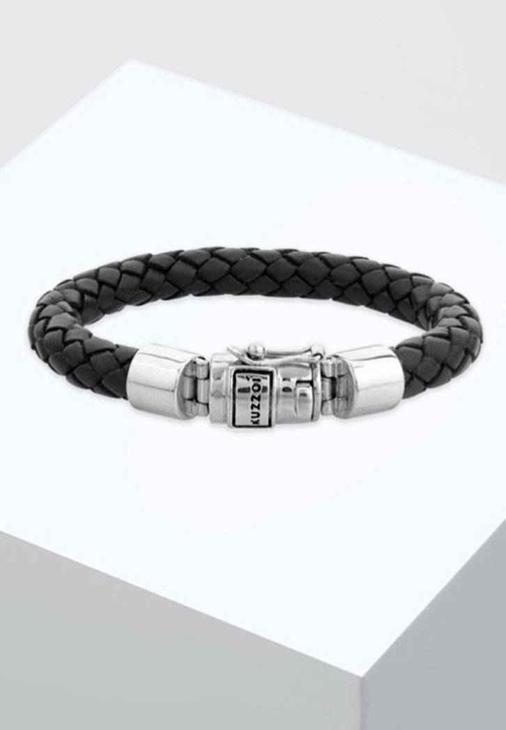 Bracciale in pelle nera intrecciata con chiusura in tonalità argento con incisione. La chiusura dispone di un meccanismo di chiusura sicuro e una superficie liscia.