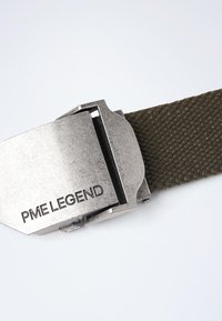Ceinture en tissu tissé vert avec une boucle en métal argenté gravée "PME LEGEND." La boucle a une forme rectangulaire et une texture lisse.