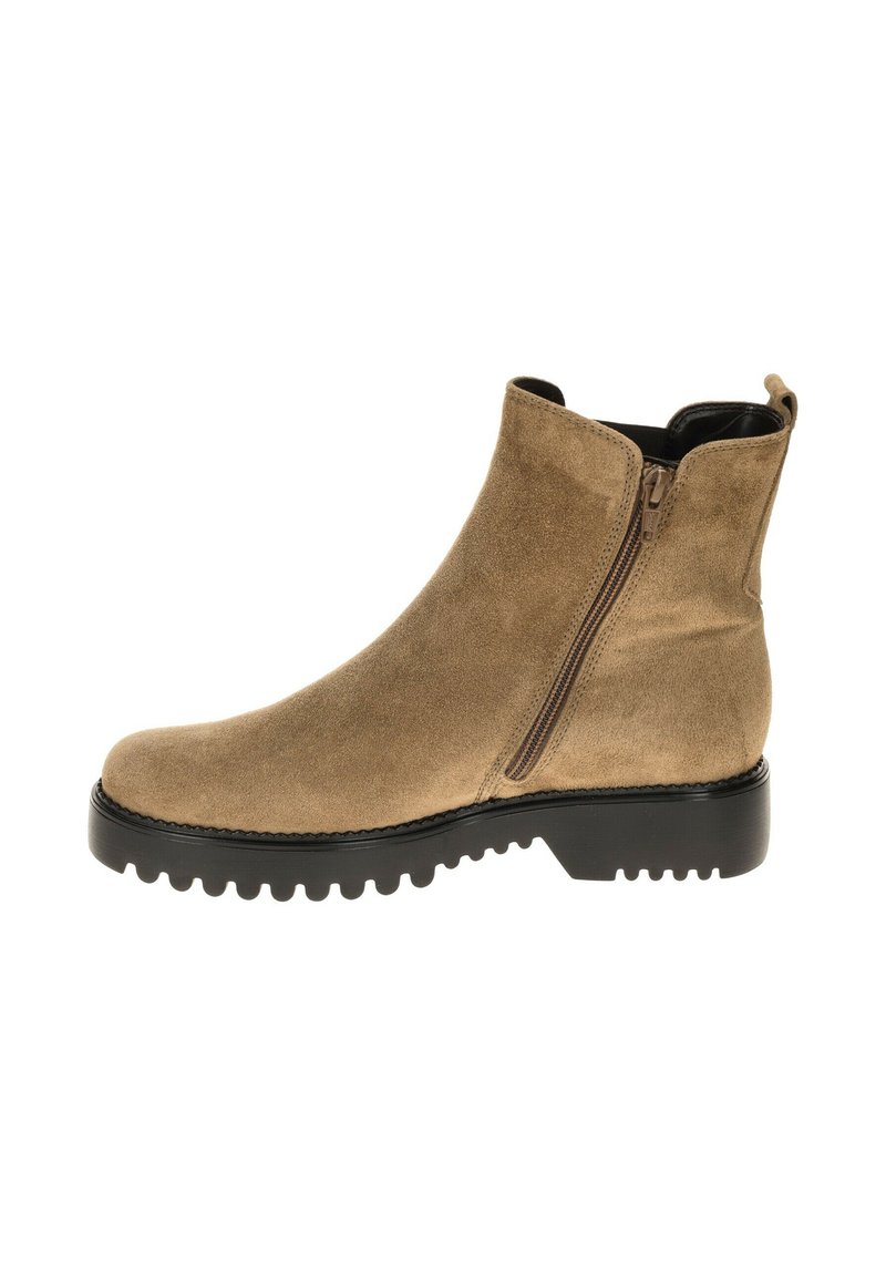 Beige suède enkellaars met een zijrits, een ronde neus en een robuuste zwarte rubberen zool met diepere profielgroeven voor grip.