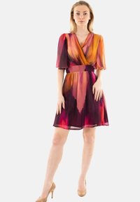 Vestido de manga corta en vibrante degradado de naranja, rosa y púrpura. Diseño envolvente con cintura ajustada y falda acampanada; tejido ligero y fluido.