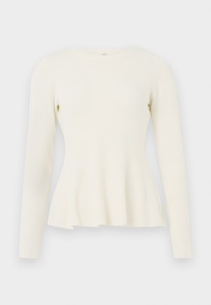 Haut en tricot côtelé à manches longues en blanc cassé avec un col rond et un ourlet évasé. Texture douce avec un corsage ajusté et un bas fluide.