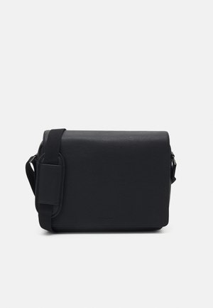 Czarna torba na ramię z teksturowanego materiału, o prostokątnym kształcie, z regulowanym paskiem i prostym, minimalistycznym designem.