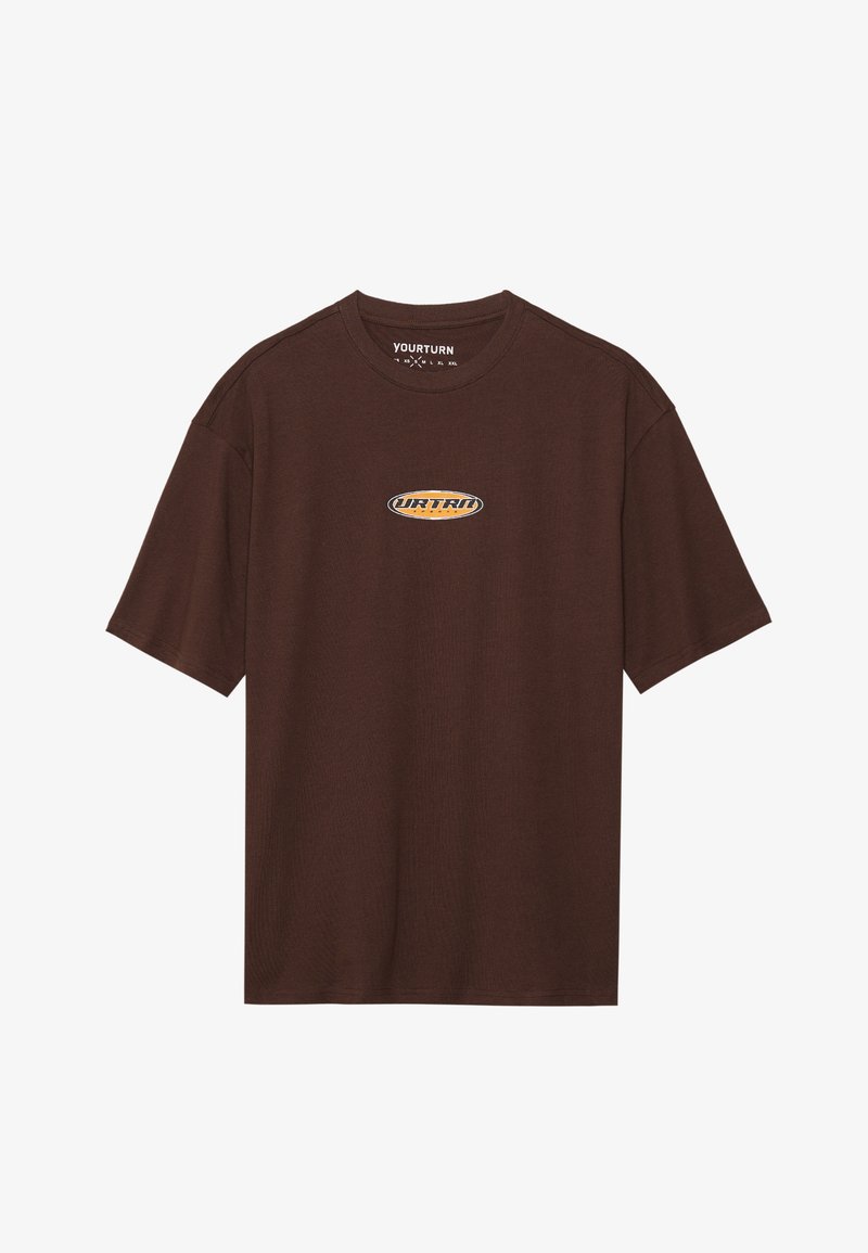 Barna pamut póló, kerek nyakkal, rövid ujjakkal, narancssárga és sárga grafikával a mellkasán. Simább tapintású.