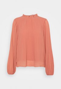 Blouse couleur pêche avec manches longues plissées et col à volants. Confectionnée en tissu léger avec une coupe décontractée.