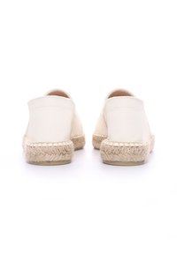 Espadrillas bianche in tela con suole in corda e dettagli di cucitura. Parte posteriore arrotondata, stile slip-on, texture liscia, design minimalista.