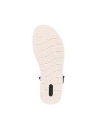 Semelle extérieure en caoutchouc blanc avec des rainures texturées et un logo noir. Surface lisse avec des lignes courbes pour une meilleure adhérence et flexibilité.