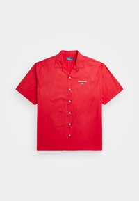 Red short-sleeve shirt made of cotton. Features a button front, pointed collar, and small embroidered logo on the left chest.
