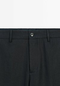Dark gray trousers with a textured fabric, featuring a standard waistband, a single button closure, and side pockets.