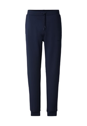 Marineblå joggebukser laget av mykt stoff, med snøring i midjen, tilpassede ben og ribbestrikkede mansjetter. Diskret logodetalj på siden.