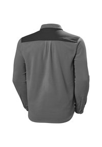 Szara koszula z długim rękawem z czarną wstawką na ramionach, o gładkiej fakturze i detalach przy mankietach z guzikami. W luźnym kroju.