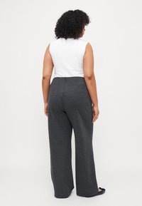 Gray wide-leg pants in soft fabric, paired with a fitted white sleeveless top. The outfit has a casual, relaxed fit with a smooth texture.
