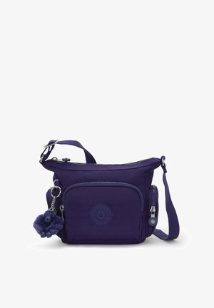 Lila Nylon-Crossbody-Tasche mit einem Reißverschluss-Hauptfach, einer Vortasche, einem Logo-Emblem und einem flauschigen Affen-Schlüsselanhänger als Zubehör.