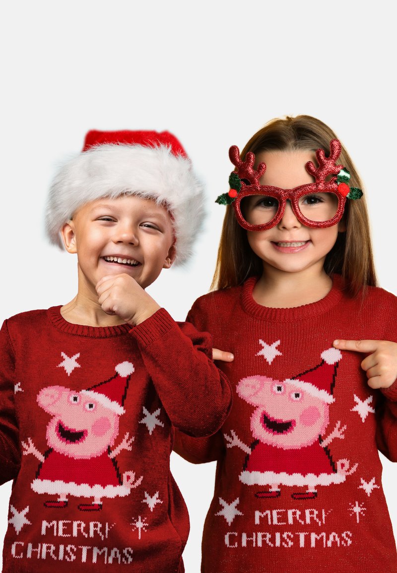 Maglioni di Natale rossi con un personaggio di maiale in un cappello di Babbo Natale, con il testo "BUON NATALE" e motivi a stella. Bambini che indossano accessori festivi.
