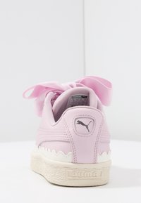 Rosa Sneaker mit einem strukturierten Lederoberteil, gewellter weißer Mittelsohle und einer großen, bandähnlichen Schnürung. Mit einem kleinen Puma-Logo an der Ferse.