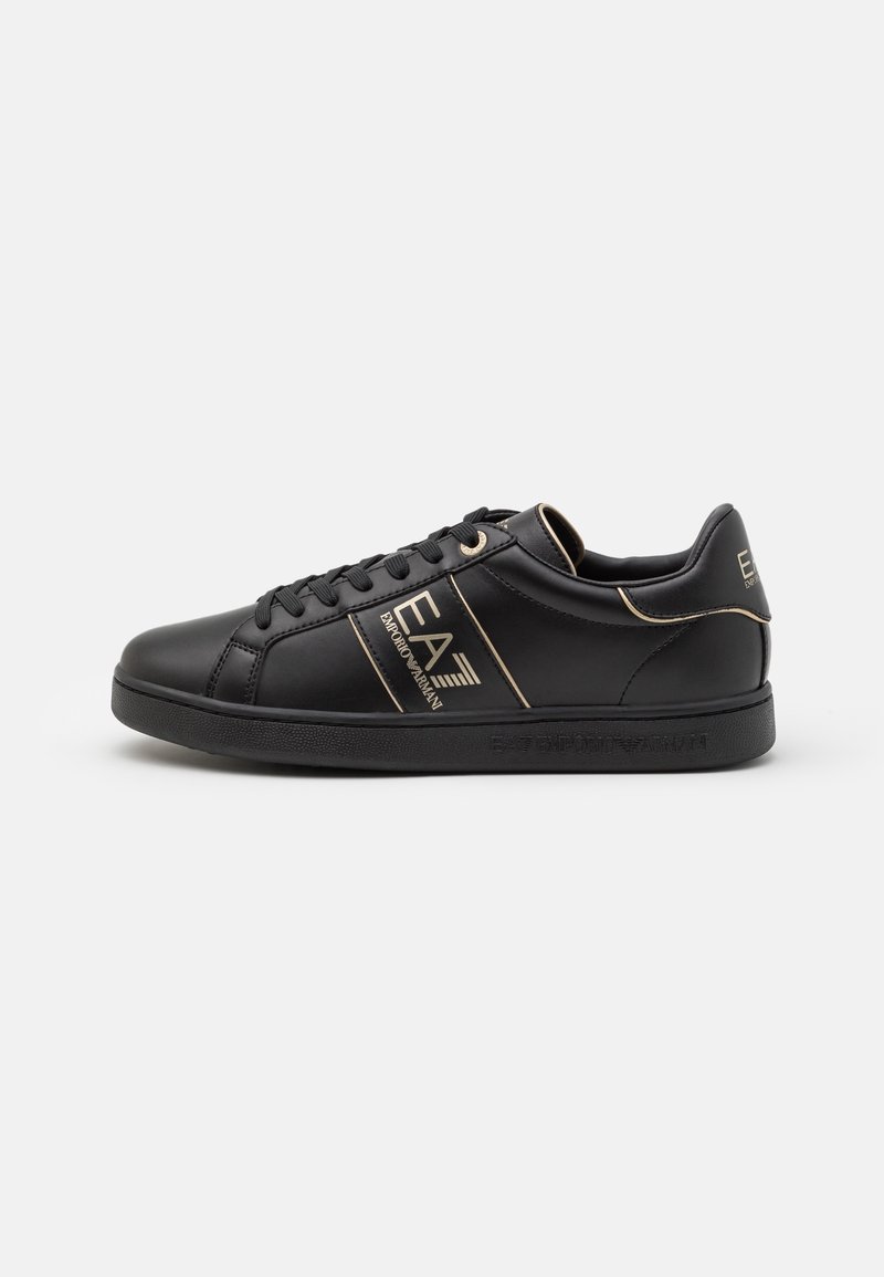 Baskets basses noires avec lacets noirs, marquage doré EA7 Emporio Armani sur le côté et le talon, et semelle noire texturée.