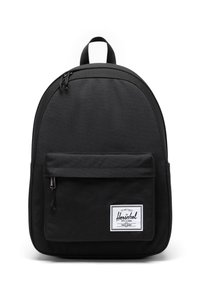 Czarny plecak z tkaniny o zaokrąglonym kształcie, z przednią kieszenią na zamek i wyraźną łatą z logo. Posiada podwójne zapięcia na suwak oraz uchwyt na górze.