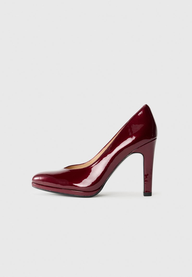 Escarpin en cuir verni bourgogne avec un bout arrondi, surface lisse, talon de 10 cm et design de plateau subtil.