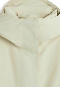 Ljusbeige hooded jacka med en smidig textur, minimala sömmar och en ren, strömlinjeformad design utan synlig hårdvara eller utsmyckningar.