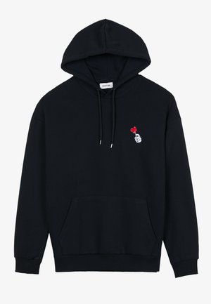 Svart hettegenser laget av bomull, med en frontlomme, justerbar snøring på hetta, og en liten brodert grafikk av en hånd med et hjerte.