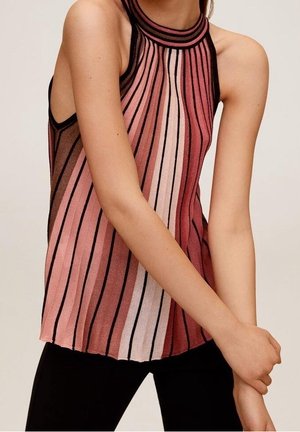 Haut sans manches à col halter avec des rayures verticales dans des tons de rose, mauve et noir, porté avec un pantalon noir, modèle croisant les bras à la taille.