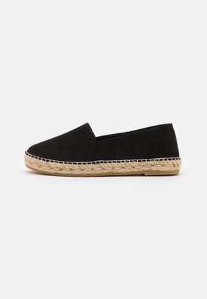 Alpargata negra con parte superior textil lisa y suela de yute trenzado. Diseño de punta redondeada y base plana para mayor comodidad. Sin herrajes visibles ni patrones.