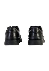 Sneaker in pelle nera con finitura liscia, colletto imbottito e suola a profilo basso. Presenta un sottile dettaglio di cucitura e suola in gomma.