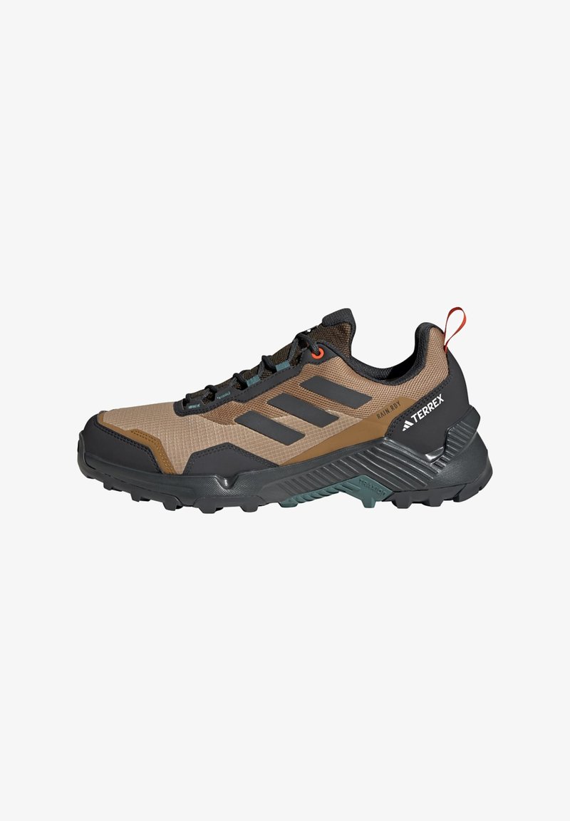 Brown and black athletic shoe with mesh upper, rubber sole, and prominent three-stripe design. Features a reinforced toe and a pull tab.