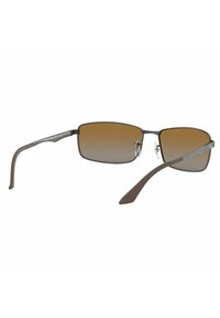 Occhiali da sole rettangolari con gradiente marrone e montatura in metallo. Caratteristiche includono un doppio ponte, cuscinetti per il naso flessibili e aste delle tempie di colore opaco.