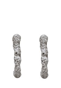 Texturerade metalörhängen med en organisk, oregelbunden form, en matt silverfinish och ytdetaljer av små indragningar.