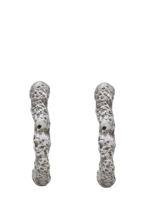 Textured metal earrings featuring an organic, irregular shape with a matte silver finish and surface detailing of small indentations.