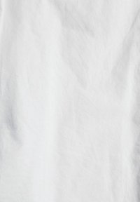 Tissu en coton blanc avec une texture légèrement froissée, affichant une surface lisse et une variation minimale de couleur ou de motif.