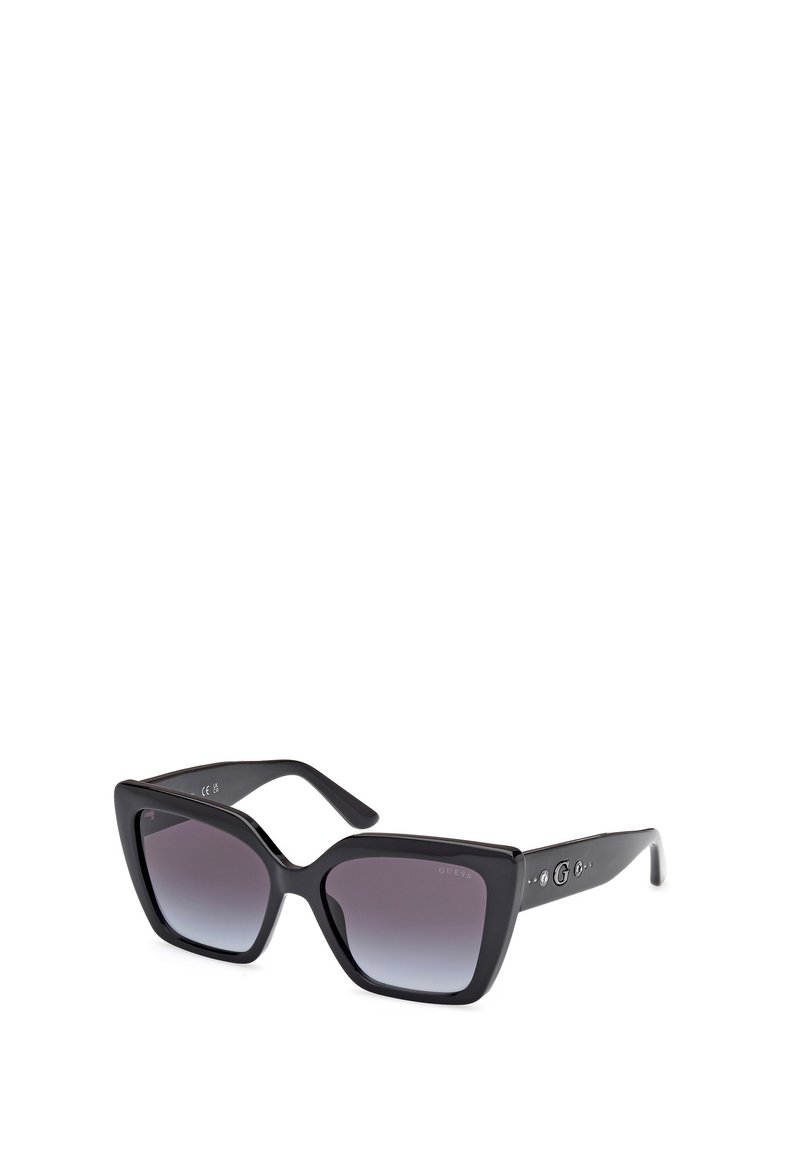 Black oversized sunglasses with gradient lenses, angular frame design, and metal logo accents on the temples. Glossy finish.
