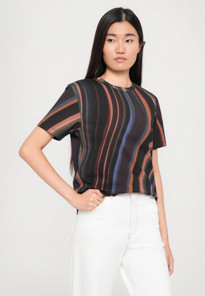 Short-sleeve top in dark fabric featuring multicolored vertical stripes. Round neckline, relaxed fit, smooth texture, paired with white pants.