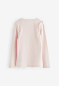 Chemise côtelée rose clair à manches longues avec un col rond, vue de dos sur fond blanc.
