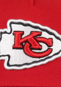 Rote Kappe mit gesticktem weißen und schwarzen Rand, auf dem "KC" in roten Buchstaben steht. Strukturierter Stoff mit prominentem Teamlogo.