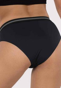 Melna augsta jostas apakšbikses ar gludu tekstūru un kontrastējošām pelēkām svītrām gar jostasvietu, ar klasisku griezumu un vienkāršu dizainu.