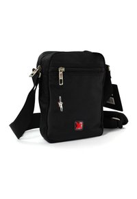 Zwarte crossbodytas met verstelbare strap, een voorvak met rits, een kleine figuurtje sleutelhanger en het rode Zwitserse kruislogo op de gestructureerde stof.