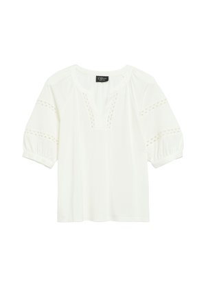 Blouse blanche à manches courtes avec col en V, motifs décoratifs découpés sur les manches et près de l'encolure, et poignets élastiques.