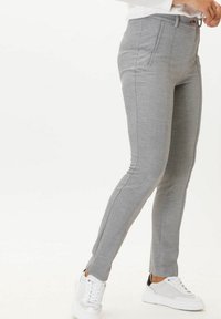 Tailored gray trousers in a textured fabric, featuring a slim fit, side pockets, and a button closure, paired with white sneakers.