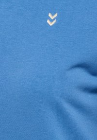 Lichtblauw kortesleevenshirt van katoen, met een zachte textuur en een klein wit chevronlogo op de linker bovenkant.